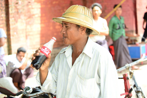 A Myanmar citizen enjoying a Coca-Cola produced in the country for the first time in more than 60 ye ... 
