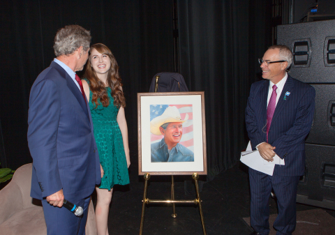 President George W. Bush accepts a portrait from Morgan Davidson, a 21-year-old illustration major a ... 