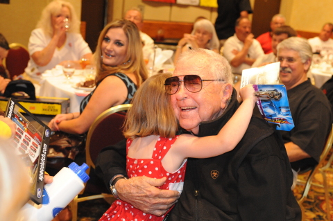 Carroll Shelby hugging a little girl at a charity event. (Photo: Business Wire)