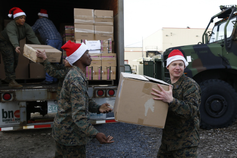 A group of Marines unload a truck full of books, toys and games donated by Barnes & Noble to Toys fo ... 