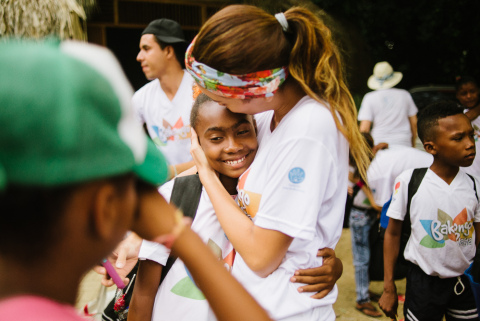 A counselor hugging a camper at the end of their immersive peace and reconciliation experience at Ca ... 