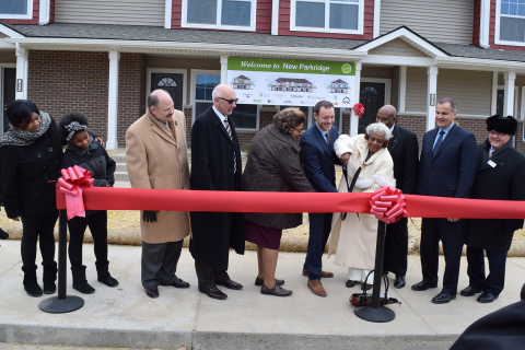 Community leaders, project partners, housing advocates and residents celebrate the grand opening of  ... 