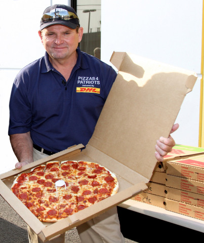 Mark Evans, founder of Pizza 4 Patriots, shows off one of the pizzas that was sent to troops overseas as part of the Guinness Book of World Records' largest pizza delivery in history. (Photo: Business Wire)
