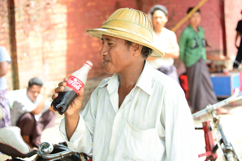 A Myanmar citizen enjoying a Coca-Cola produced in the country for the first time in more than 60 ye ... 