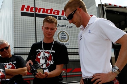 Student team member from FIRST(R) Robotics Competition (FRC(R)) Team "Robowranglers" from Greenville, Texas shows IZOD IndyCar series racer Charlie Kimball the inner-workings of his team's robot at the Firestone 550 at Texas Motor Speedway on June 8, 2013. (Photo: Business Wire)