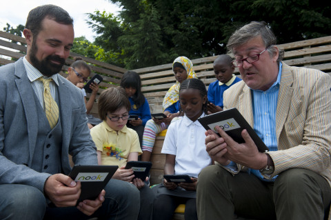 Stephen Fry reads to pupils at the Jubilee School in Tulse Hill on a NOOK(R) HD+ tablet. Fry was at the school to announce the latest additions to the stellar line-up of celebrities and authors attending the NOOK-sponsored free Get Reading festival on 13th July in Trafalgar Square. (Photo: Business Wire)