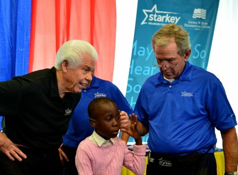 Former President George W. Bush and Bill Austin, founder of the Starkey Hearing Foundation, fit a patient with hearing aids at a mission in Dar es Salaam. (Photo: Starkey Hearing Foundation)