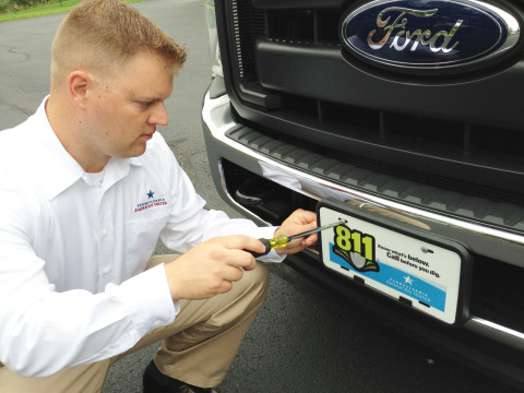 To help raise awareness of PA One Call, Pennsylvania American Water Production Supervisor George Cradic attaches "call before you dig" plate to company vehicle. (Photo: Pennsylvania American Water)