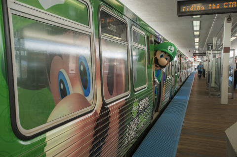 In this photo provided by Nintendo of America, Luigi gets ready for his morning commute on the Luigi-themed Chicago 'L' train on Aug. 12, 2013. Taking the 'Year of Luigi' to a whole new level, the train's interior and exterior are wrapped with a Luigi theme through Sept. 8 in celebration of the Year of Luigi and New Super Luigi U, which launches as a packaged game for Wii U on Aug. 25, 2013. (Photo by Peter Barreras/Invision for Nintendo/AP Images)