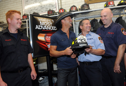 Country music star Tim McGraw, center, shares a moment with FDNY firefighters at an event in New York, Thursday, Aug. 15, 2013, announcing the launch of Duracell's new powerful Quantum battery and the donation of one million to first responders. (Diane Bondareff/Invision for Duracell)