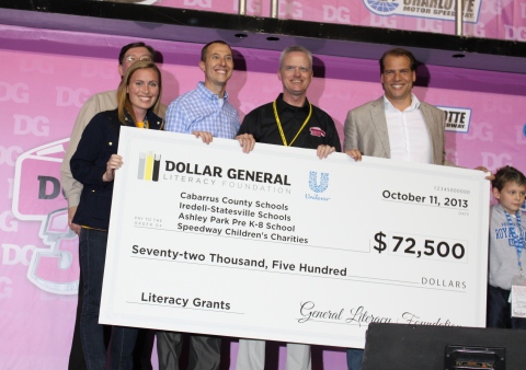 David Tehle, Dollar General's executive vice president and chief financial officer (middle) and Krees Kruythoff, Unilever North America's President (right) present a check for $72,500 to Charlotte-area educators in pre-race ceremonies at the Dollar General 300 as part of the Reading Puts You on the Track to Victory program. (Photo: Business Wire)