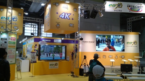 The Sony 4K Bravia TV is displayed on the left and featured content streamed in real-time 4K/HEVC by Elemental. Traditional live broadcast is displayed on the right. The public was able to view 4K live coverage of the marathon in a special K-OPTICOM exhibit during the race. (Photo: Business Wire)