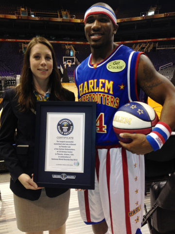 Harlem Globetrotters rookie Thunder Law, pictured with Guinness World Records® PR and marketing executive Sara Wilcox, broke the Guinness World Records record for the longest basketball shot, with a successful shot of 109 feet 9 inches. (Photo: Business Wire)