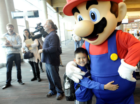 In this photo provided by Nintendo of America, video game icon Mario greets Wilson N. from Ocoee, FL, one of the lucky passengers on Southwest Airlines flight 1883 from New Orleans to Dallas Love Field who received free Wii U systems on Nov. 26, 2013. As the official video game partner of Southwest Airlines, Nintendo is partnering with Southwest Airlines to bring Wii U, Nintendo's newest home console, and family-friendly games to terminals across the country this holiday season. (Photo: Business Wire)