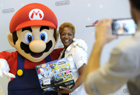 In this photo provided by Nintendo of America, Dorcas H. from La Place, LA, is one of the first passengers to thank Mario for giving away free Wii U systems on a Southwest Airlines flight from New Orleans to Dallas Love Field in Dallas, TX on Nov. 26, 2013. Nintendo is partnering with Southwest Airlines to bring Wii U, Nintendo's newest home console, to terminals across the country during the holiday season. (Photo: Business Wire)