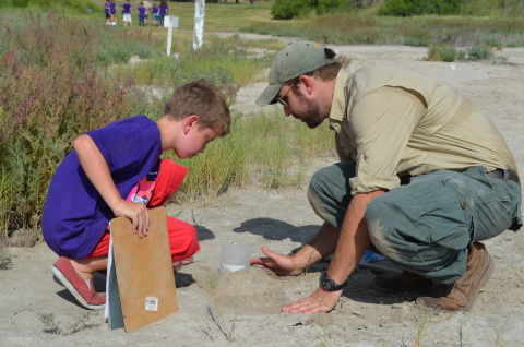 A student from Texas A&M Kingsville (right) helps with a plaster mold of a raccoon track at Flint Hills Resources' Wildlife Learning Preserve in Corpus Christi, Texas. Each summer, kids from the Texas State Aquarium's SeaCamp program visit the preserve to learn about wetlands ecology and wildlife habitat management. The preserve is among six Koch companies' sites recertified by the Wildlife Habitat Council recently. (Photo: Business Wire)