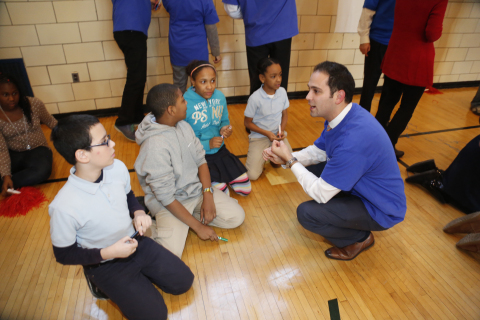 UnitedHealthcare's Victor Destefano meets with students from PS 15 as they prepare for a health trivia/physical fitness relay. The race was part of an event to kick off the second year of a collaboration between UnitedHealthcare and New York Giants Hakeem Nicks' nonprofit, Helping Hands. The organization provides backpacks of healthy foods and snacks for in-need children to take home over the weekends, when they may not otherwise have access to nutritious meals, through organizations like Blessings in a Backpack, which also joined in the afternoon's activities (Photo: Joe Rosen/PhotoBureau Inc.).