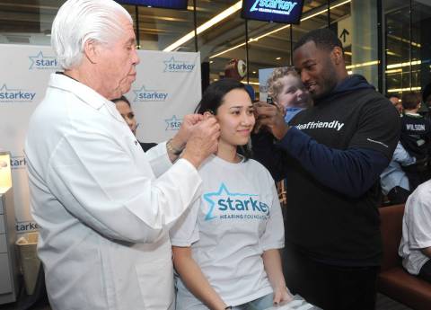 IMAGE DISTRIBUTED FOR STARKEY HEARING FOUNDATION - Seattle Seahawk Derrick Coleman, right, the first legally deaf offensive player in the NFL, and Bill Austin, Founder of Starkey Hearing Foundation, fit Victoria Pon,16, of Queens, NY, with free hearing aids at the Foundation's hearing mission, Saturday, Feb. 1, 2014, at Yankee Stadium in New York. (Photo by Diane Bondareff/Invision for Starkey Hearing Foundation/AP Images)