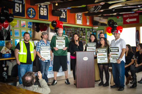 Sara Berns, Executive Director of Discover Pacific Beach, unveils the long awaited designated driver parking signs that will soon be spotted around Pacific Beach. (Photo: Business Wire)
