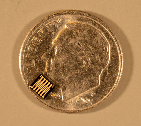 A die containing 400 ohmic MEMS switches, as viewed under a microscope, atop a U.S. dime. This device, made with GE's Metal MEMS process, is capable of handling greater than 1kW in this tiny form factor. For mobile applications, the technology can be scaled down and miniaturized. (Photo: Business Wire)