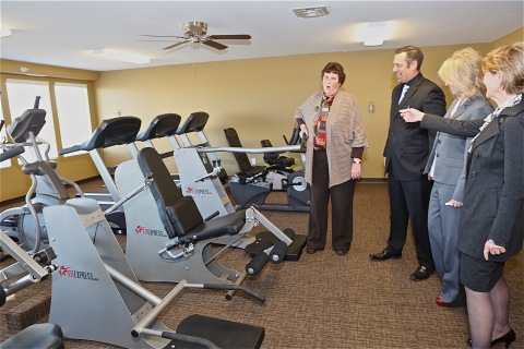 Fort Collins Mayor Karen Weitkunat tests out the fitness equipment at the Legacy Senior Residences, a new affordable-housing community for senior citizens, during a ribbon-cutting and grand-opening event today. The $14.7 million 72-unit development was funded in large part through a $13 million investment by UnitedHealth Group, including its Optum and UnitedHealthcare businesses, in Colorado. The company teamed up with U.S. bank for the tax credit partnership. Additional partners included the Cornerstone Development, the City of Fort Collins, the Fort Collins Housing Authority and the Colorado Housing and Finance Authority. L to R: Mayor Weitkunat; Matt Zarlengo, U.S. Bank; Bobbi Jo Lucas, Cornerstone Associates; and Jan Eyer, Optum of Colorado (Photo: Craig Vollmer).