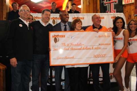 Hooters presents a $200,000 check to The V Foundation for Cancer Research at the Hooters of West End in Dallas during the excitement of the men's college basketball tournament finals. (L-R: Mike Burkey, Director of Operations, Hooters Texas Division; Bruce Skala, Vice President of Marketing, Hooters of America; Jay Williams, ESPN analyst; Susan Braun, CEO, The V Foundation; Dick Vitale, ESPN analyst and board member of The V Foundation; Marissa Raisor, Miss Hooters International) (Photo: Business Wire)