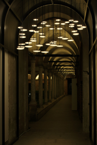 会場入り口の回廊に配置された50台の面発光LED照明器具「パネルミナ」のペンダントライト(Photo by Satoshi Shigeta)