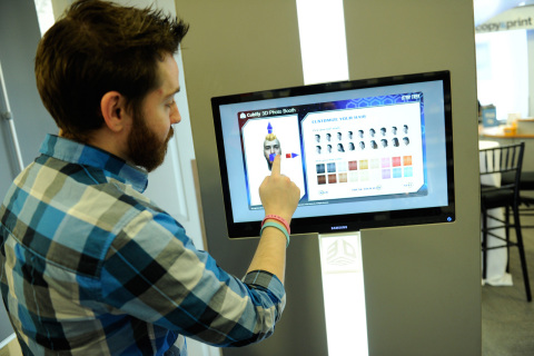 3D Systems' Adam Reichental demonstrates the capabilities of the 3D printing photo booth at Staples' experience center in its New York City store. (Photo: Business Wire)