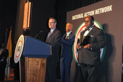 AHF President Michael Weinstein (at podium) accepts a "Keepers of the Dream" award from Rev. Al Sharpton (back left) and Rev. Dr. W. Franklyn Richardson, Nation Action Network Chairman (back right, holding award) at the 16th annual "Keepers of the Dream" awards gala in New York City on April 9, 2014 (Photo: Business Wire)