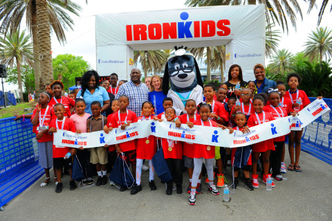 From L to R: Darrell Guy, director of the Boys and Girls Club of New Orleans (checkered shirt), and local club members are pictured with April Golenor, president, UnitedHealthcare Community Plan of Louisiana, and mascot Dr. Health E. Hound at the UnitedHealthcare IRONKIDS New Orleans. UnitedHealthcare and IRONKIDS provided 100 complimentary registrations to the Boys and Girls Club of New Orleans, and also made a $3000 donation to the organization to support youth health programs. Photo Credit: Cheryl Gerber