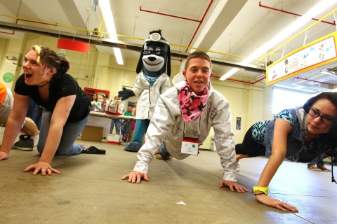 UnitedHealthcare mascot Dr. Health E. Hound watches Ethan Jacobsen, of Newburgh, N.Y., Orange County, do push-ups. He was participating in interactive stations based on the "Choose Health: Food, Fun, and Fitness" curriculum created in the Division of Nutritional Sciences at Cornell University. Youth also had the opportunity to make their own healthy smoothies with renewable energy bikes equipped with specially installed pedal-powered blenders at the New York State Fairgrounds in Syracuse, N.Y., on Saturday, April 12, 2014. (Photos by Michael J. Okoniewski)