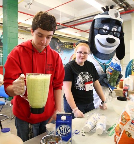 Ben Davis, left, and Jacquelyn Moroe and UnitedHealthcare's mascot, Dr. Health E. Hound, make a healthy smoothie. Davis is from Moravia, Cayuga County, while Moore is from Marathon, Cortland County. They participated in interactive stations based on the "Choose Health: Food, Fun, and Fitness" curriculum created in the Division of Nutritional Sciences at Cornell University. 4-H Youth also had the opportunity to make their own healthy smoothies with renewable energy bikes equipped with specially installed pedal-powered blenders at the New York State Fairgrounds in Syracuse, N.Y., on Saturday, April 12, 2014. (Photos by Michael J. Okoniewski)