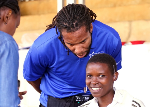 Larry Fitzgerald, Arizona Cardinals wide receiver, fits a patient with hearing aids at a Starkey Hearing Foundation mission in Butare, Rwanda in March. (Photo: Business Wire)