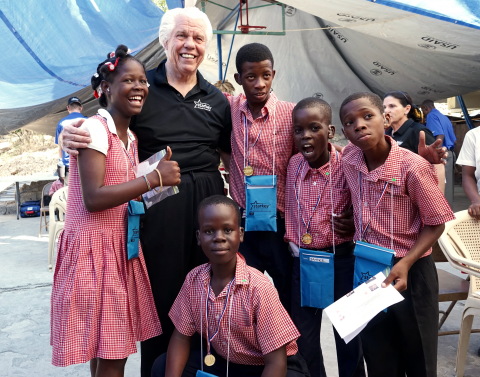 Bill Austin, founder of Starkey Hearing Foundation, shares a laugh with patients who received free hearing aids at a mission in Port au Prince, Haiti in January. (Photo: Business Wire)