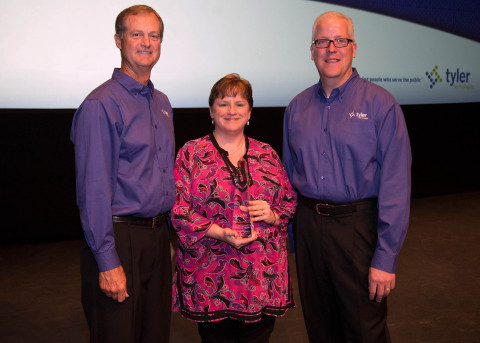 Steve Nieman, senior vice president of Tyler's Local Government Division, and Brett Cate, president of Tyler's Local Government Division, present a Tyler Excellence Award to Ridgeland's Deputy Director of Finance and Information Services Ina Byrd. (Photo: Business Wire)