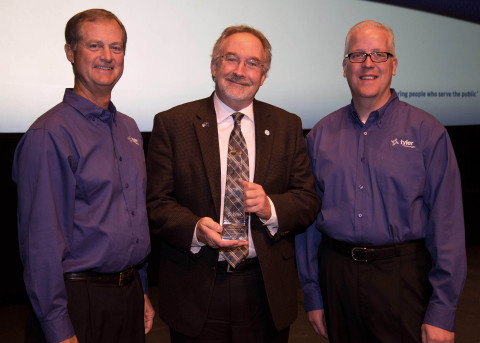 Steve Nieman, senior vice president of Tyler's Local Government Division, and Brett Cate, president of Tyler's Local Government Division, present a Tyler Excellence Award to Washoe County's Recorder Larry Burtness. (Photo: Business Wire)