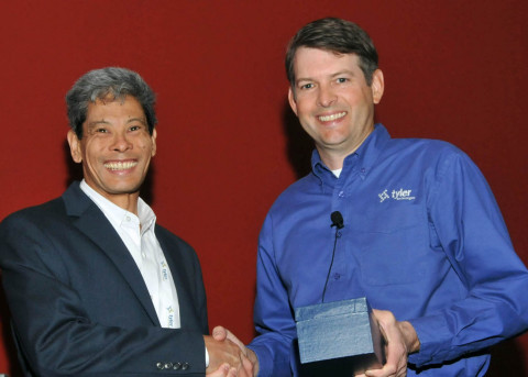 Desmond Chin, finance director at the village of Palmetto Bay, accepts a Tyler Excellence Award from Jeff Green, senior vice president at Tyler. (Photo: Business Wire)