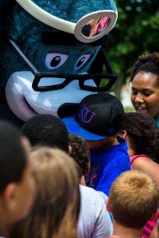 Youth from the Boys & Girls Club of Lawrence hug UnitedHealthcare's mascot Dr. Health E. Hound. More than 150 youth participated in the UnitedHealthcare IRONKIDS Kansas Fun Run at Clinton State Park. UnitedHealthcare sponsored the race and made a $3,000 donation to the Boys & Girls Club of Lawrence in support of youth healthy living programs and provided free race entries. Source: Kelly Prier.