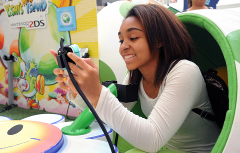 In this photo provided by Nintendo of America and released June 7, 2014, Teoko P., 17, of Los Angeles plays "Yoshi's New Island" in a Yoshi egg-shaped seat at the Westfield Culver City mall on June 6, 2014, as part of the "Play Nintendo Tour 2014," which kicked off in Los Angeles on June 6. The free three-month tour will visit malls and events in a dozen major cities across the United States. Nintendo 2DS is an ideal first-time system. (Photo by Nintendo/Bob Riha, Jr.)
