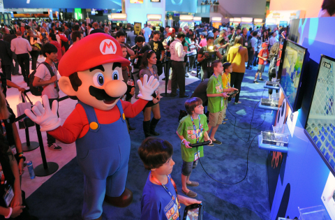 In this June 11, 2014, photo provided by Nintendo of America, Evan, 8, Caleb, 11, Jonah, 12, and Noah, 13, visit Nintendo's booth during E3 and become the first kids in the world to score exclusive hands-on time with Splatoon, a new video game for the Wii U console that Nintendo announced at the trade show in Los Angeles.