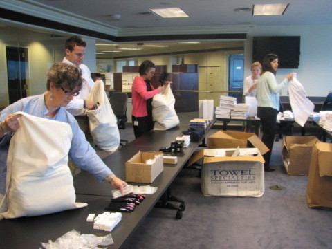 Volunteers from Loomis, Sayles & Co. assemble care packages for uAspire Last Dollar Scholarship recipients on July 29, 2014. (Photo: Business Wire)