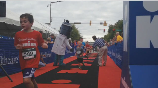 U.S. Congressman Chuck Fleishmann and UnitedHealthcare mascot Dr. Health E. Hound give high-fives to athletes as they finish their quest to become IRONKIDS at the UnitedHealthcare Chattanooga Fun Run. Source: Kevin Herglotz