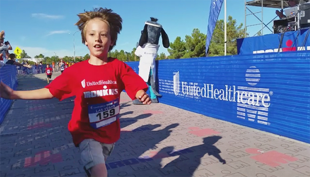 UnitedHealthcare mascot Dr. Health E. Hound is pictured at the finish line of the UnitedHealthcare IRONKIDS Las Vegas Fun Run at Henderson Pavilion. More than 200 youth participated in today's race for "triathletes to be." (Video credit: Kin Lui)