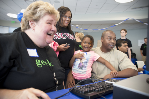 MetLife volunteer shows Jasmine Phillips and her parents some of the programs on her new computer. (Photo: Business Wire)