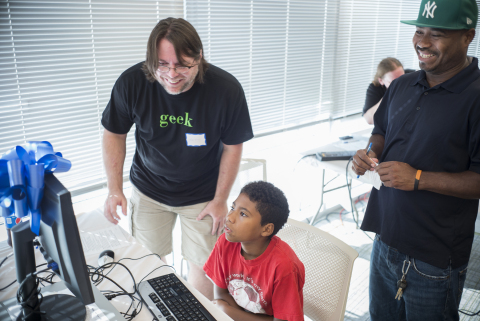 Alvaro Perez Dina learning to use his new computer with his dad and a MetLife volunteer (Photo: Business Wire)