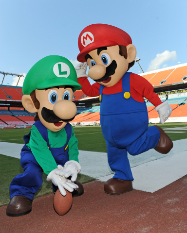 In this photo provided by Nintendo of America, Mario and Luigi take the field at Sun Life Stadium before the face-off between Florida State and University of Miami on Nov. 15, 2014. The two video game icons were in town to show football fans Super Smash Bros. for Nintendo 3DS and the forthcoming Super Smash Bros. for Wii U. Nintendo of America is bringing these all-star brawling games to college campuses across the country this fall as a part of the College Tailgate Tour.