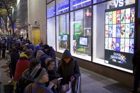 In this photo provided by Nintendo of America, fans wait in line at Nintendo World in New York on Nov. 20, 2014, to be among the first in the U.S. to purchase Super Smash Bros. for Wii U, amiibo figures as well as Pokémon Omega Ruby and Pokémon Alpha Sapphire for the Nintendo 3DS family of systems. 