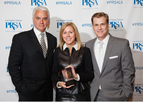50th Annual PRism Awards emcee John O'Hurley (left) and PRSA-LA President Erik Deutsch present coveted President's Award for the most awards won during the 2014 PRism Awards Show to DeAnn Marshall, Senior Vice President, Chief Development and Marketing Officer, Children's Hospital Los Angeles (CHLA). It was the third consecutive year CHLA earned the President’s Award. (Photo: Business Wire)