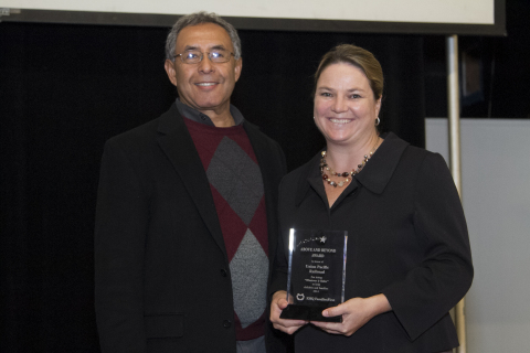 Liisa Stark of Union Pacific receives award from Roberto Favela, VP of Foster Care and Adoption Services of EMQ FamiliesFirst. (Photo: Business Wire)