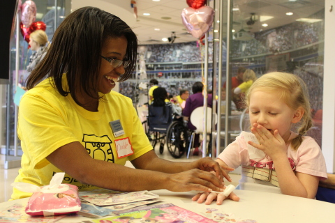 Volunteers from UnitedHealth Group brought a HeARTS-themed party to the patients and families at Children's Healthcare of Atlanta. Nichole Robeson, medical social worker, Optum Health Solutions, is pictured with a young patient at today's Project Sunshine party (Photo: courtesy of Project Sunshine).